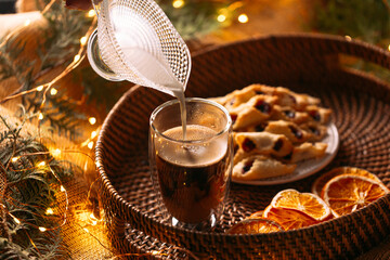 Pouring milk in a coffee on the wicker basket tray