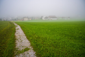A countryside road to a foggy alpine village