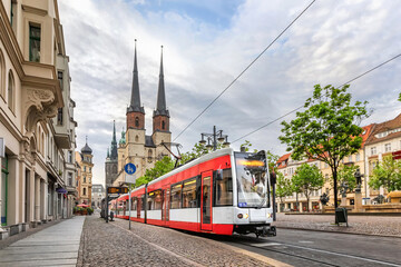 Halle (Saale), Germany. Red tram going on Hallmarkt square in front of Marktkirche church in old town - obrazy, fototapety, plakaty