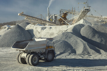 Mining dump truck on the background of the stone-crushing equipment at the mining enterprise