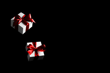 Black friday star. White gift box with red ribbon isolated on black background in Black Friday concept. Winter flying composition with copy space.