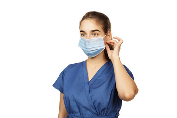 Beautiful young woman doctor surgeon putting on a protective disposable face mask isolated on white background. Virus protection concept. The modern viral threat of coronavirus