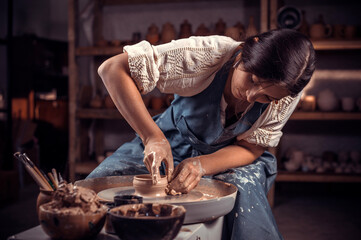Hands of the master potter and vase of clay on the potter's wheel close-up. Master crock. Twisted potter's wheel.