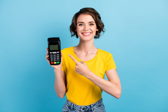 Photo of cheerful girl hold card reader indicate forefinger wear yellow t-shirt isolated blue color background