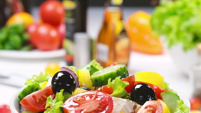 Greek salad on fork with feta cheese and olives, fresh vegetable salad served with healthy food ingredients, mediterranean cuisine