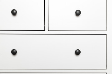 White wooden chest of drawers, front view fragment