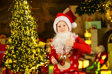 Fototapeta na wymiar Ready for holiday. kid wait for xmas presents. time to buy gifts. shopping sales. holiday preparation and celebration. small boy wear santa hat and beard. christmas time composition. happy new year
