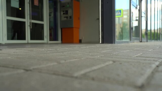 self-sliding doors of the mall, close-up people legs go out and enter the building on a summer day, slowmo