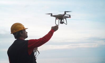 Man pilot engineer flying with drone - Video surveillance and industrial ispection concept - Focus on hand © DisobeyArt