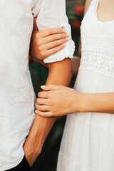 Close-up of loving couple hand in hand outdoors. Hands and hearts together forever. 