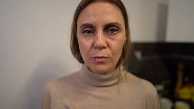 Portrait of woman having pain because of alcoholic man. Traumatised abused terrified helpless, vulnerable, beaten wife suffering injury from alcoholic violent brutal husband. Stop domestic violence