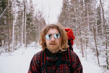 Portrait of a male traveler in the winter forest