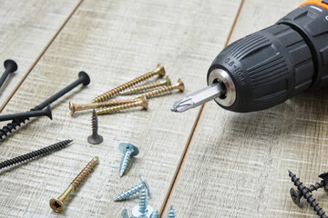 electric screwdriver, self-tapping screws,, tool box on a wooden background