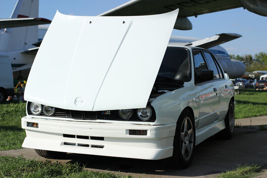 White Bmw m3 e30 with an open hood.