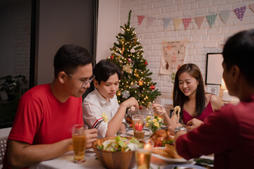 Group of Asian people eating and drinking beer at home.