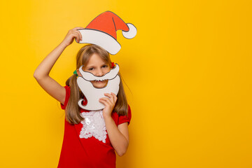 Fototapeta na wymiar Kid holding cardboard Santa hat and beard