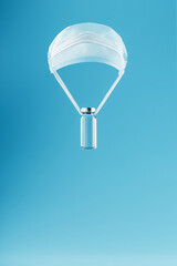 Ampoule with a vaccine against a virus and a disease on a paroshut made of protective Melecine oil on a blue background.