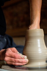 Female hands working with clay on a potter's wheel