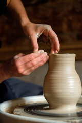 Female hands working with clay on a potter's wheel