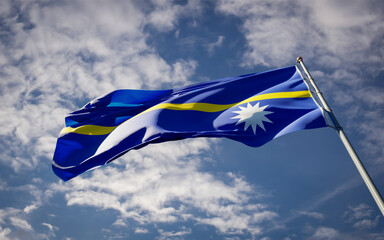 National state flag of Nauru fluttering at sky background.