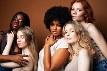 Obraz premium young pretty african and caucasian women posing cheerful together on brown background, lifestyle diverse nationality people concept