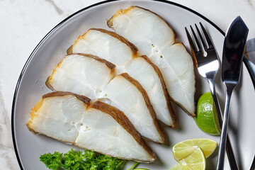 halibut fish slices on a plate, top view