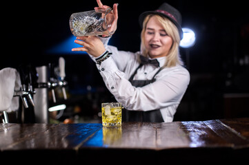 Girl barman formulates a cocktail on the alehouse