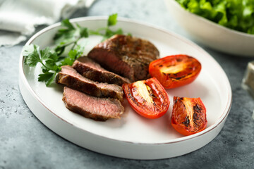 Beef steak with grilled tomatoes and parsley