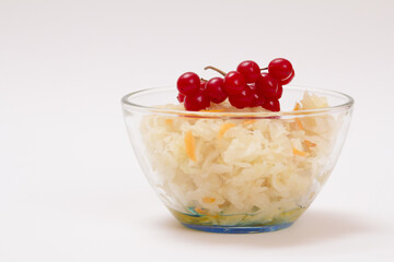 Fermented cabbage with herbs and spices in glass bowl on white background