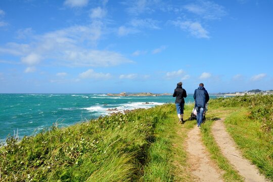 A couple walking on a path along the coast in Brittany. France