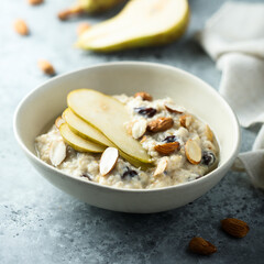 Oatmeal porridge with nuts, raisins and fresh pear