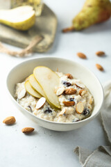 Oatmeal porridge with nuts, raisins and fresh pear