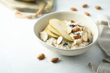 Oatmeal porridge with nuts, raisins and fresh pear