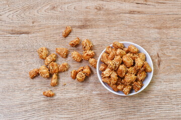 crispy sweet peanut coating syrup and dressing sesame in cup on table