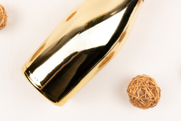 Fototapeta na wymiar part of festive champagne bottle sealed with gold foil on white wooden table background