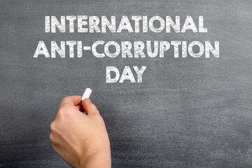 International Anti-Corruption Day, 9 December. Woman's hand with white chalk