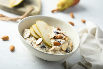 Oatmeal porridge with nuts, raisins and fresh pear