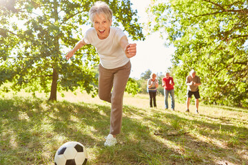 Vitale Senior Frau beim Fußball spielen