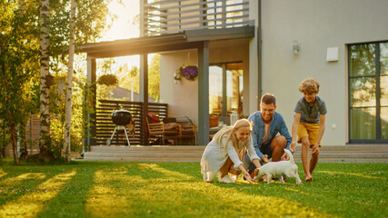 Smiling Father, Mother and Son Pet and Play with Smooth Fox Terrier Retriever Dog. Sun Shines on Idyllic Happy Family with Loyal Pedigree Dog have Fun at the Idyllic Suburban House Backyard - obrazy, fototapety, plakaty