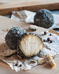 Swiss cheese Belper Knolle in the shape of small balls sprinkled with black pepper. Gourmet appetizer. Selective focus