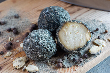 Swiss cheese Belper Knolle in the shape of small balls sprinkled with black pepper. Gourmet appetizer. Selective focus
