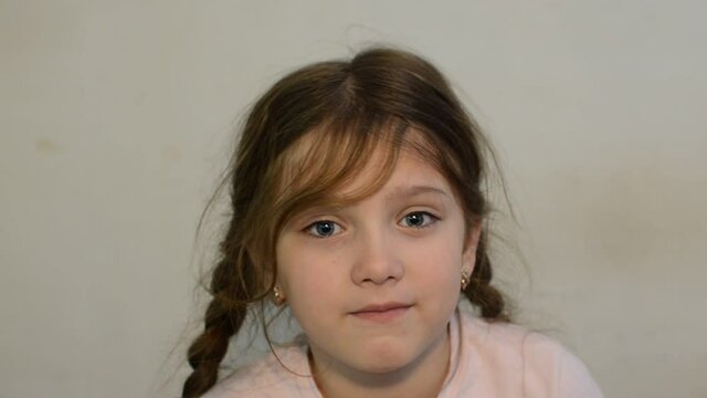 Little girl child blows snot out of nose into paper handkerchief during a cold