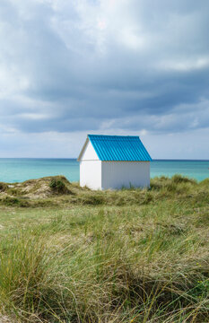 Beach hut in the dunes. Picturesque colorful wooden beach cabin at Gouville-sur-Mer, Cotentin, Normandy, France