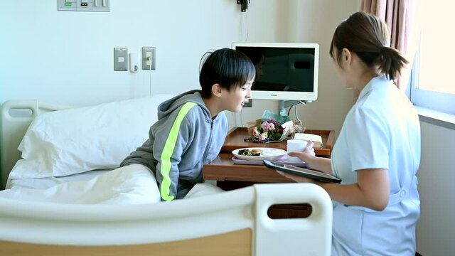 入院患者の子供が看護師から入院食の説明を受けている。