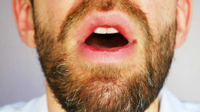 A Lower Part Of A Face Of A Doctor Taking Off A Protective Mask And Taking A Deep Breath Close-up