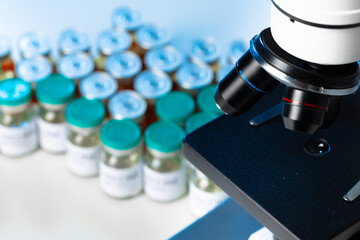 Medical vial with medication near microscope close up