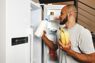 African american man taking food from a fridge in his house