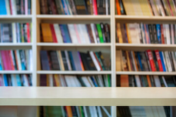 wooden table standing in front of bookshelf background.