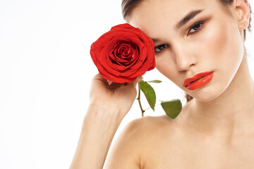 charming brunette girl with makeup on her face and a red rose in her hand