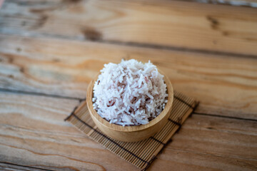 Cooked organic rice in a bowl on wooden table